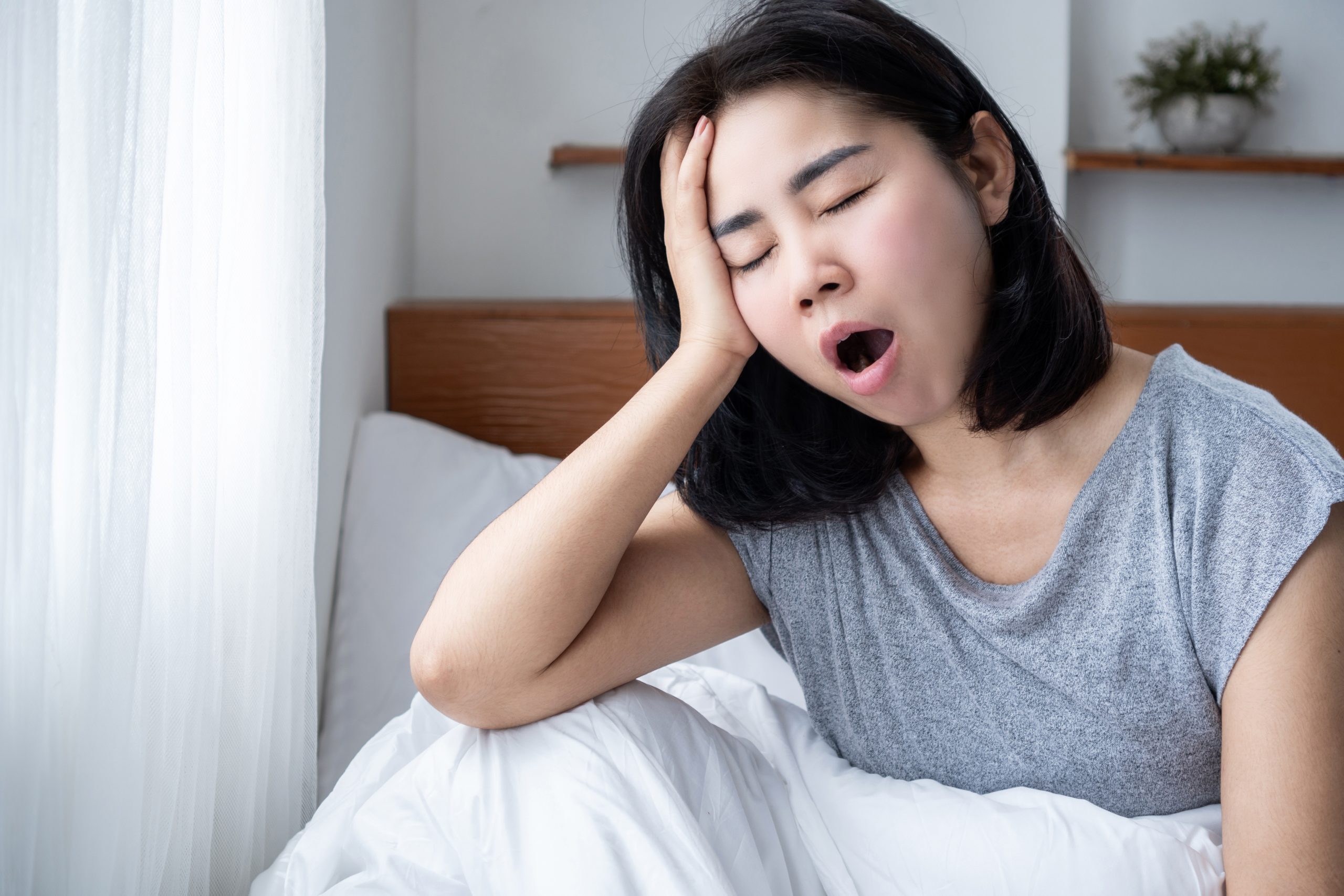 Asian woman waking up tired