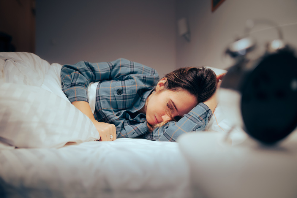 female restlessly sleeping in bed